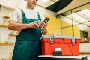 handyman using phone near toolbox